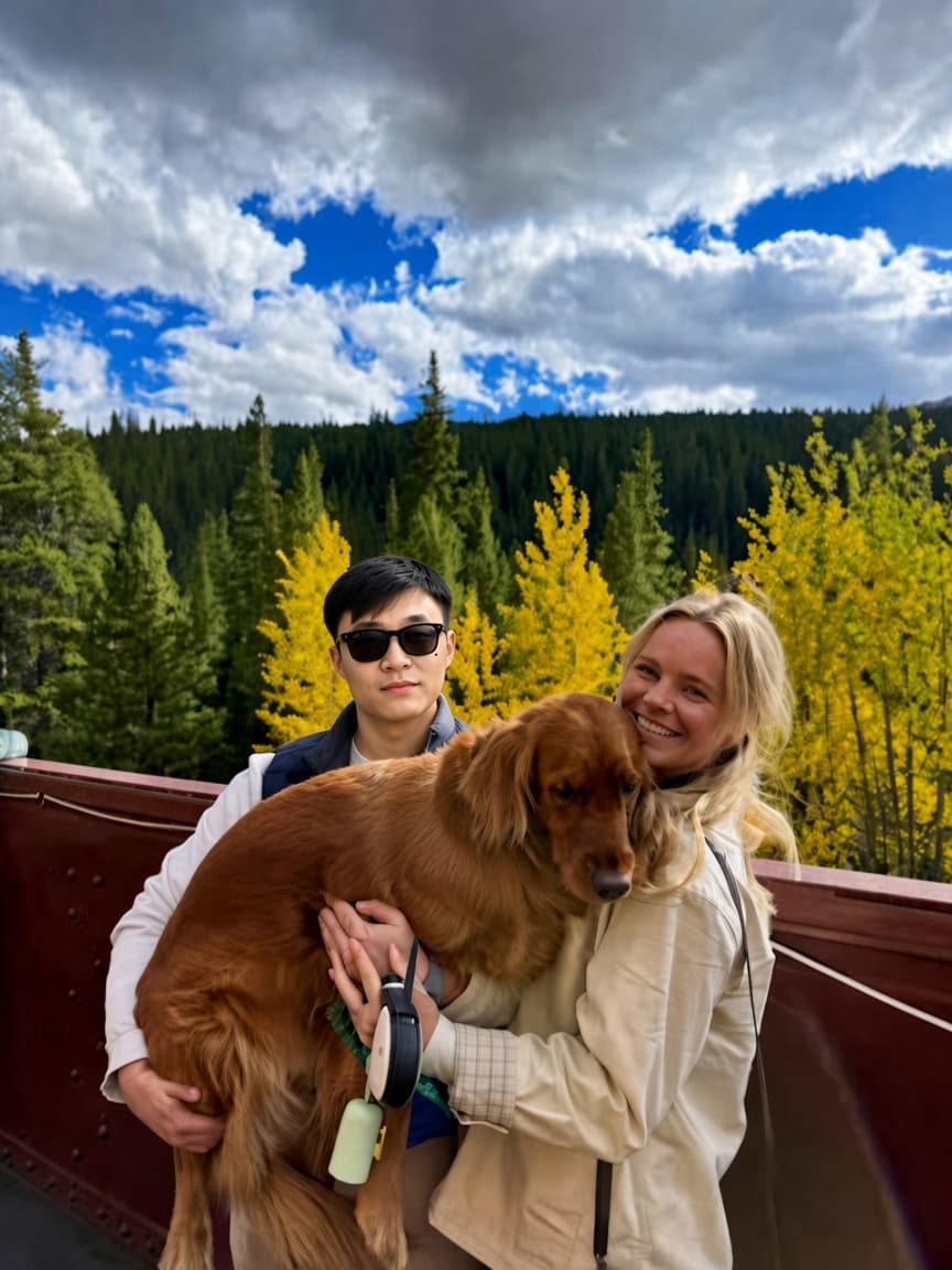 Josh holding a golden retriever on a mountain overlook